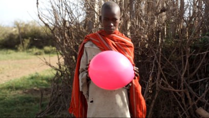 Kid holding baloon next to Sadhana Forest Kenya land
