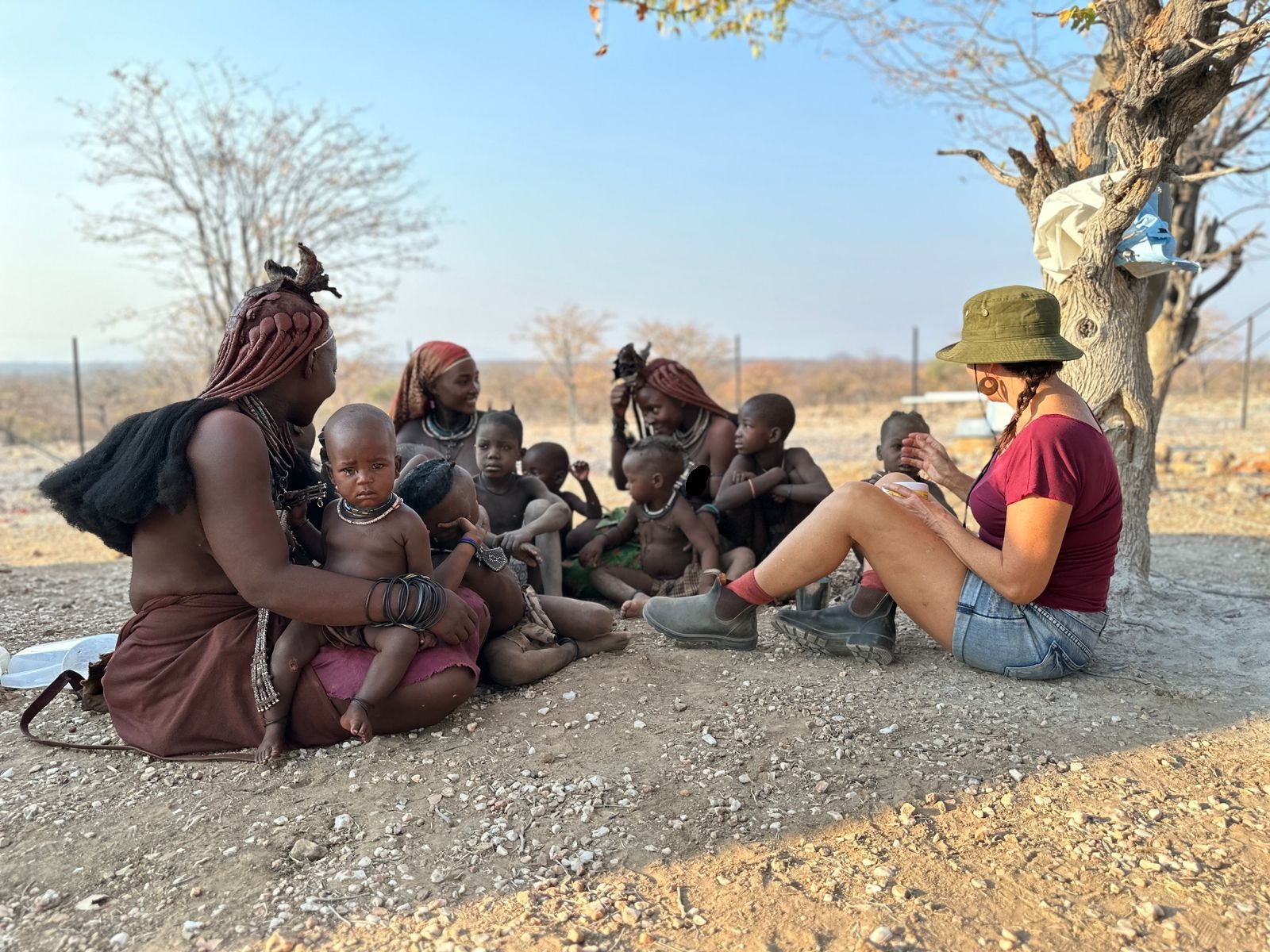 SF team member sitting with a group of Himba women and children